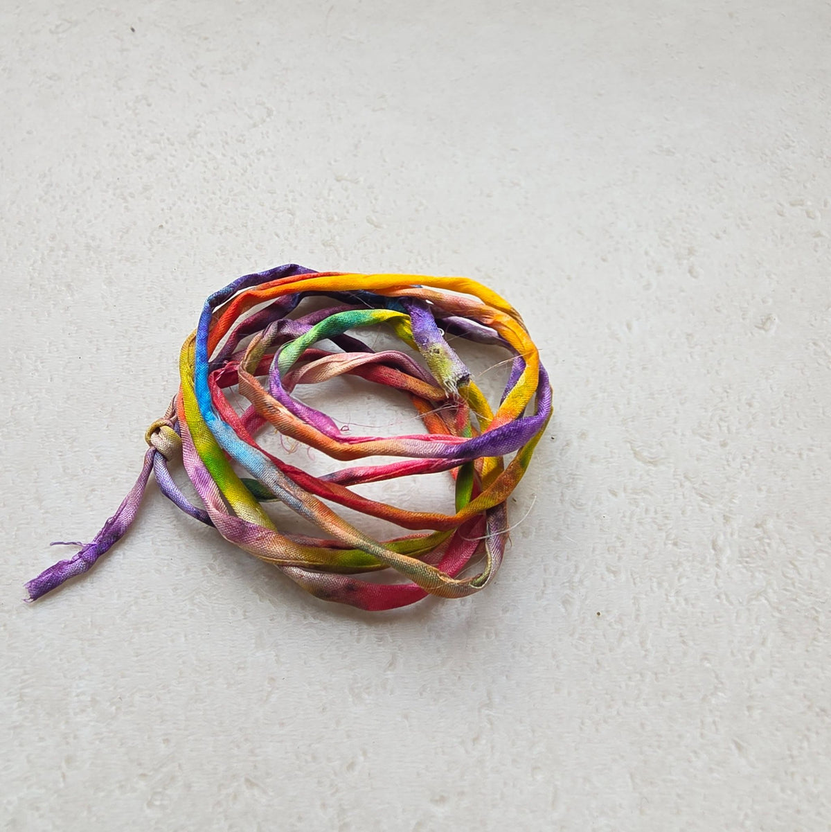 Zijden armbandje Om mij heen handgeschilderd – zonnestraaldraadje regenboog