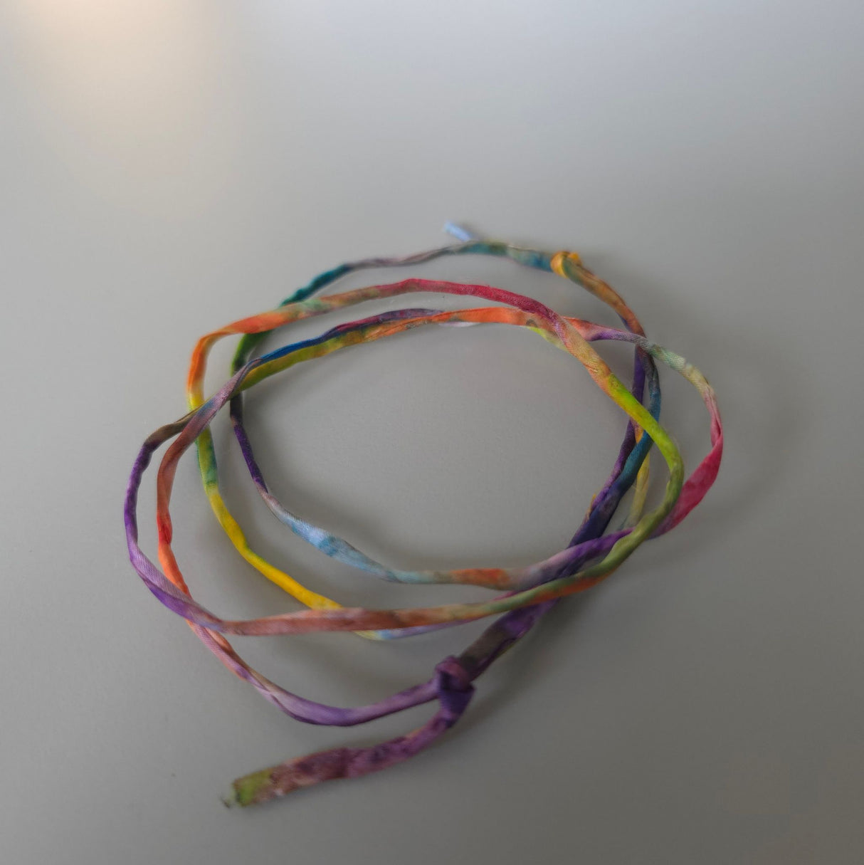 Zijden armbandje Om mij heen handgeschilderd – zonnestraaldraadje regenboog